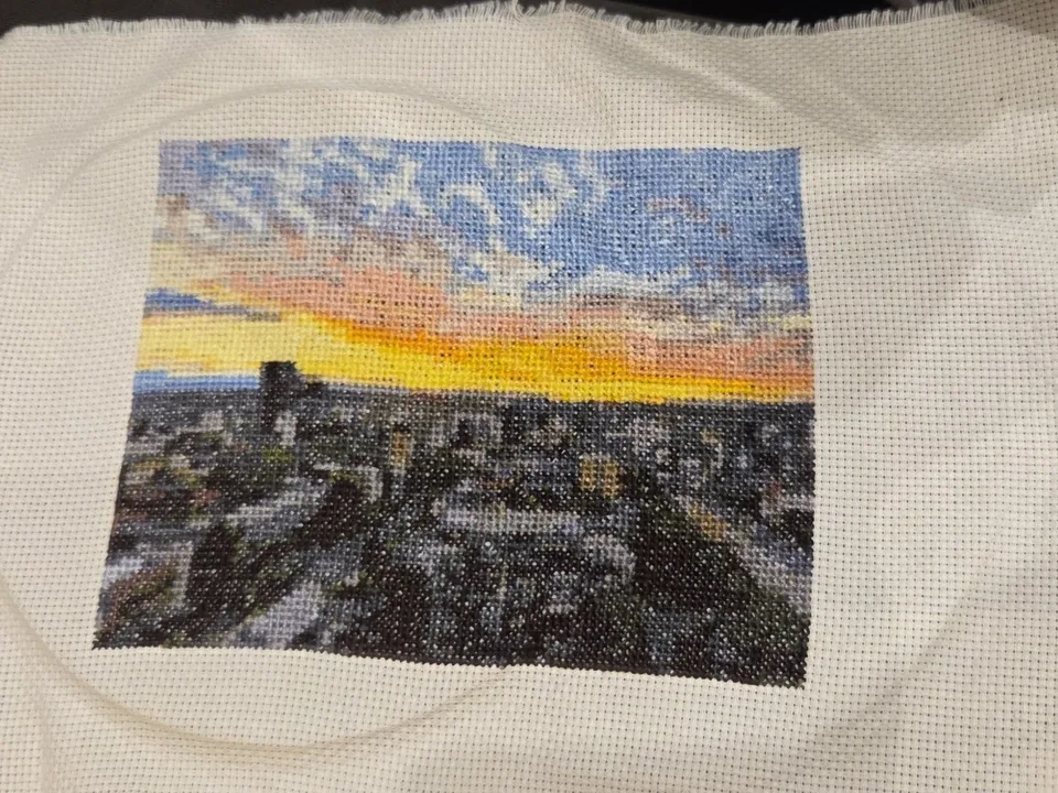 The same sunset cross stitched on white Aida fabric, just off the hoop
